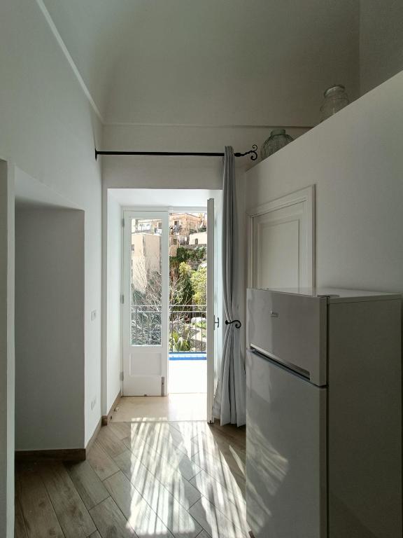 a kitchen with a refrigerator and an open door at Regina Margherita in Positano