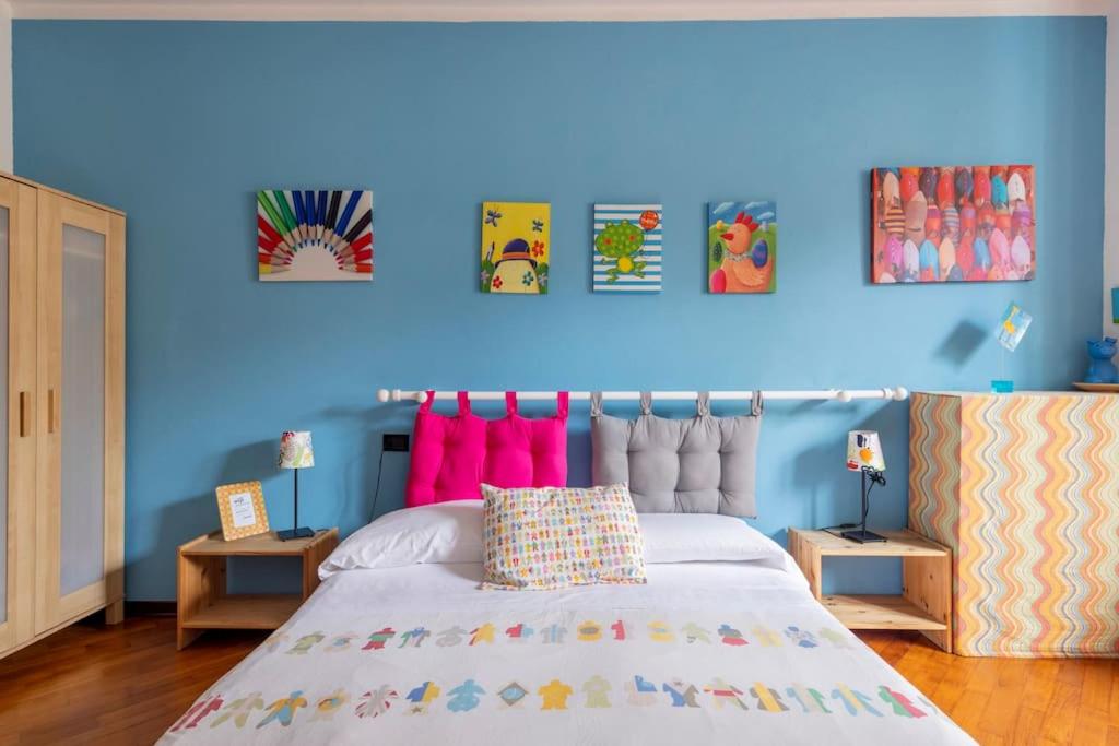 - une chambre bleue avec un grand lit et des oreillers roses dans l'établissement Antica Porta delle Cinque Terre, à Pignone