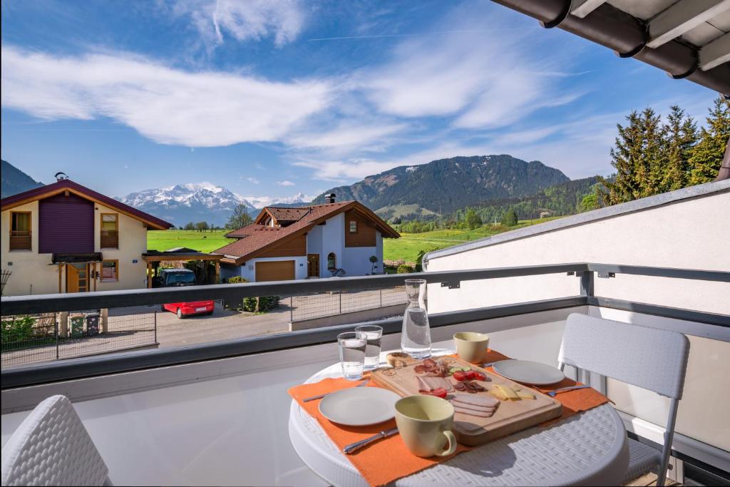 a table on a balcony with a view of mountains at Sun Valley Apartments in Maishofen
