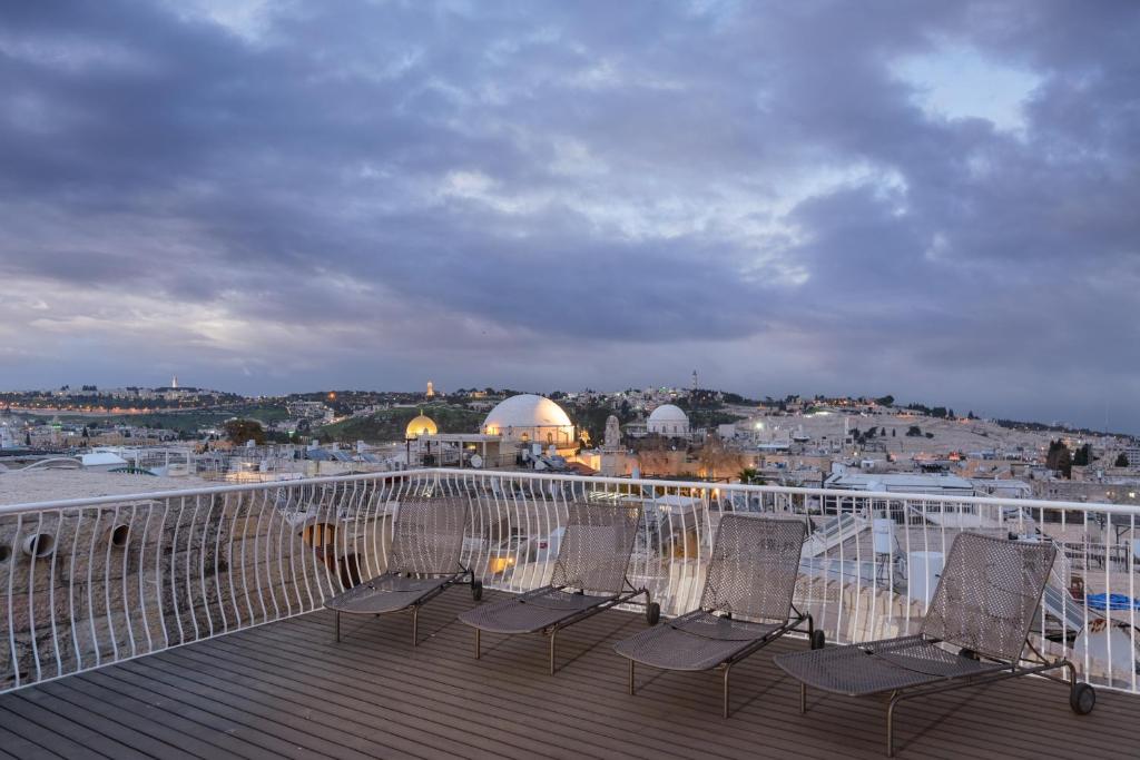 un grupo de sillas sentadas en la cubierta en Old City Luxury Duplex with Rooftop by FeelHome en Jerusalén