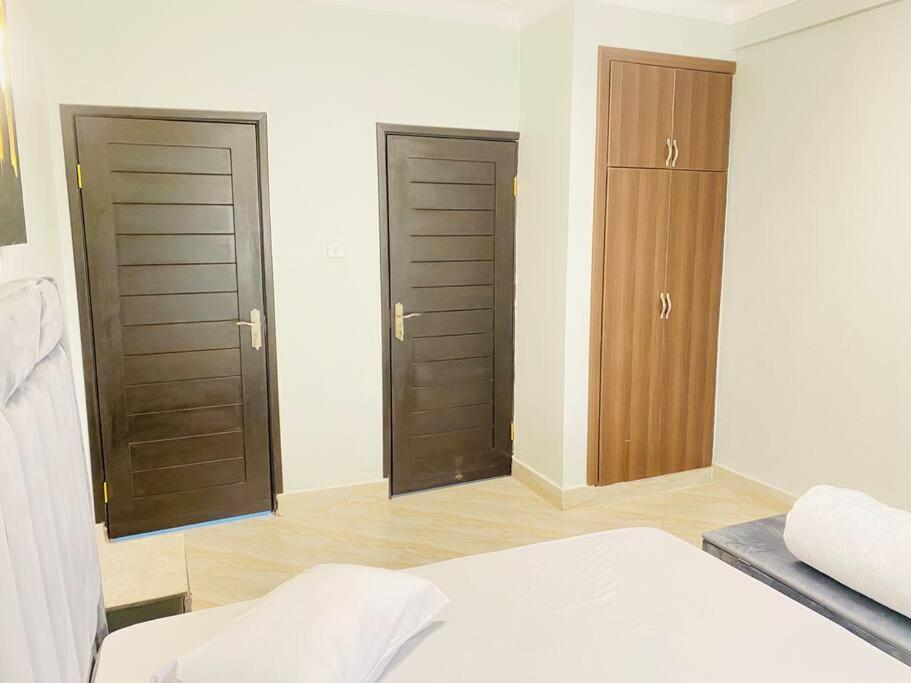 een slaapkamer met twee bruine deuren en een bed bij StarHomes, Jinja in Jinja