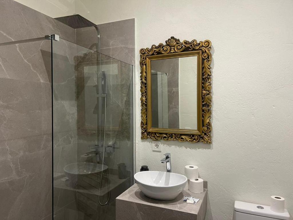 y baño con lavabo y espejo. en Palacio de los Angulo casa histórica en el centro de Córdoba en Córdoba