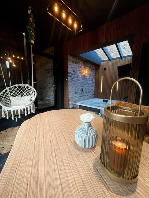 een houten tafel met een vaas erop bij Lodge Spa privatif Le Revella in Profondeville