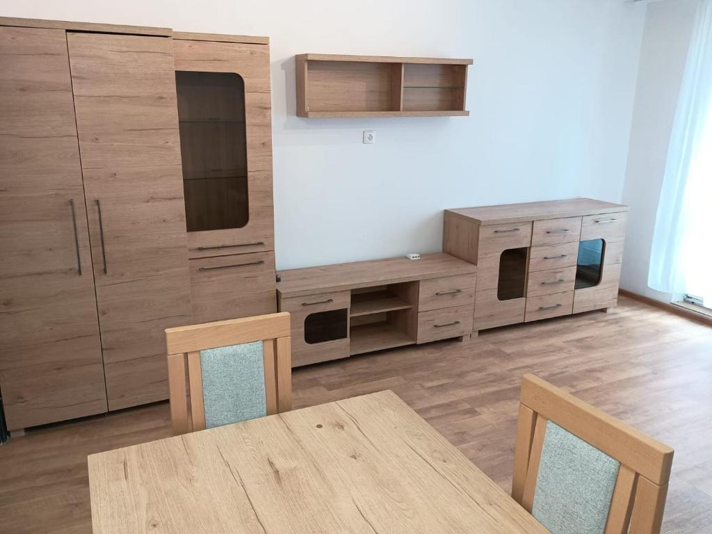 a kitchen with wooden cabinets and a wooden table at Apartament Sol in Radom