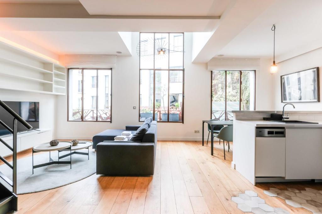 a living room with a couch and a table at Chic duplex loft in trendy Bastille in Paris