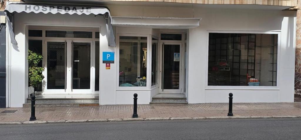 un edificio blanco con puertas de cristal en una calle en Pensión España 2 Estrellas Cehegin, en Cehegín