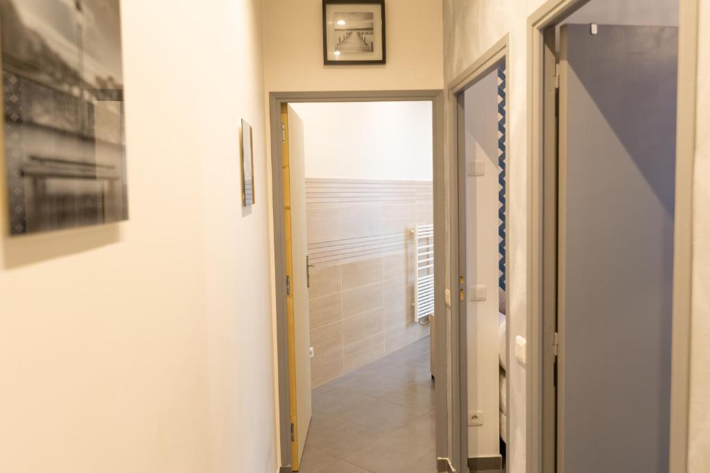 a hallway with a door leading to a bathroom at We Love Paris - Private Apartment in Vitry-sur-Seine