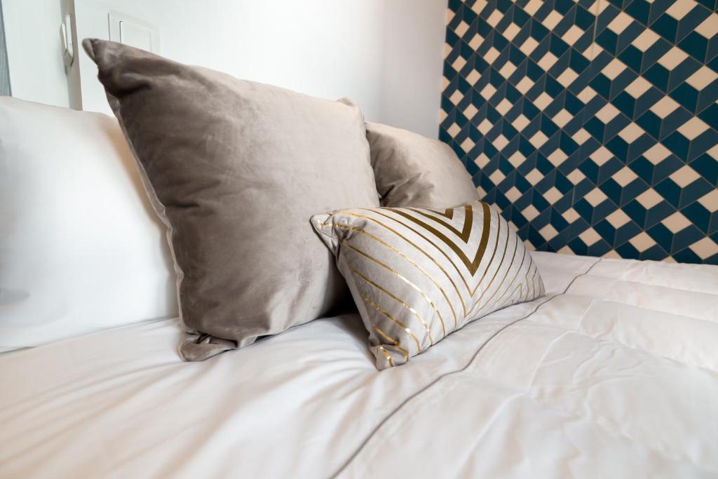 a white bed with two pillows on top of it at We Love Paris - Private Apartment in Vitry-sur-Seine