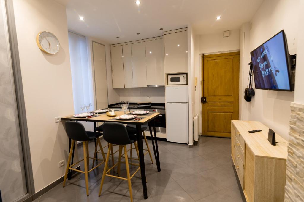 a kitchen with a table and chairs in a room at We Love Paris - Private Apartment in Vitry-sur-Seine