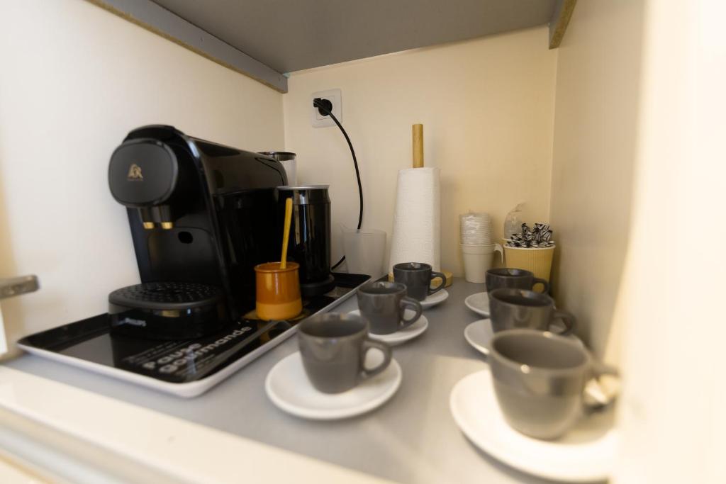 a group of coffee cups on a counter at We Love Paris - Private Apartment in Vitry-sur-Seine