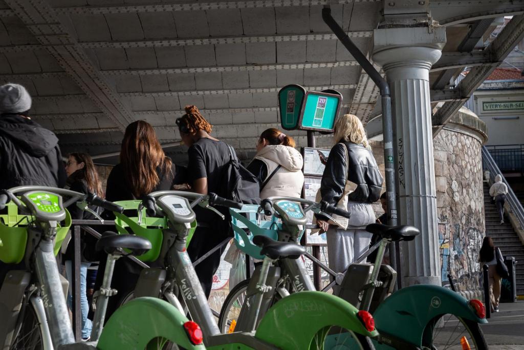 a group of people waiting for their bikes at a subway station at We Love Paris - Private Apartment in Vitry-sur-Seine