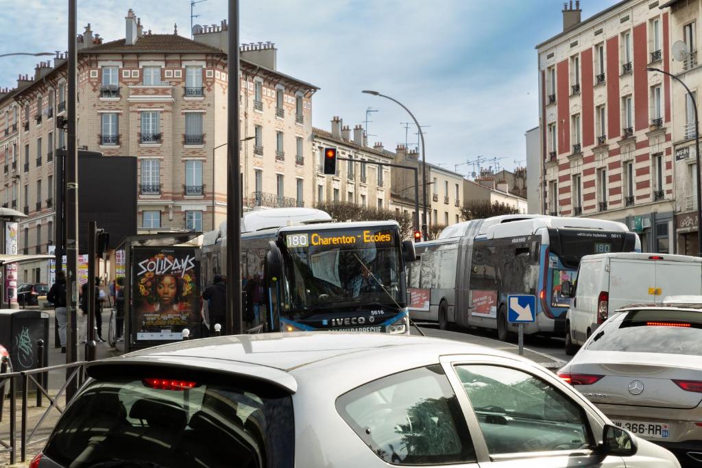a city street filled with traffic with buses and cars at We Love Paris - Private Apartment in Vitry-sur-Seine