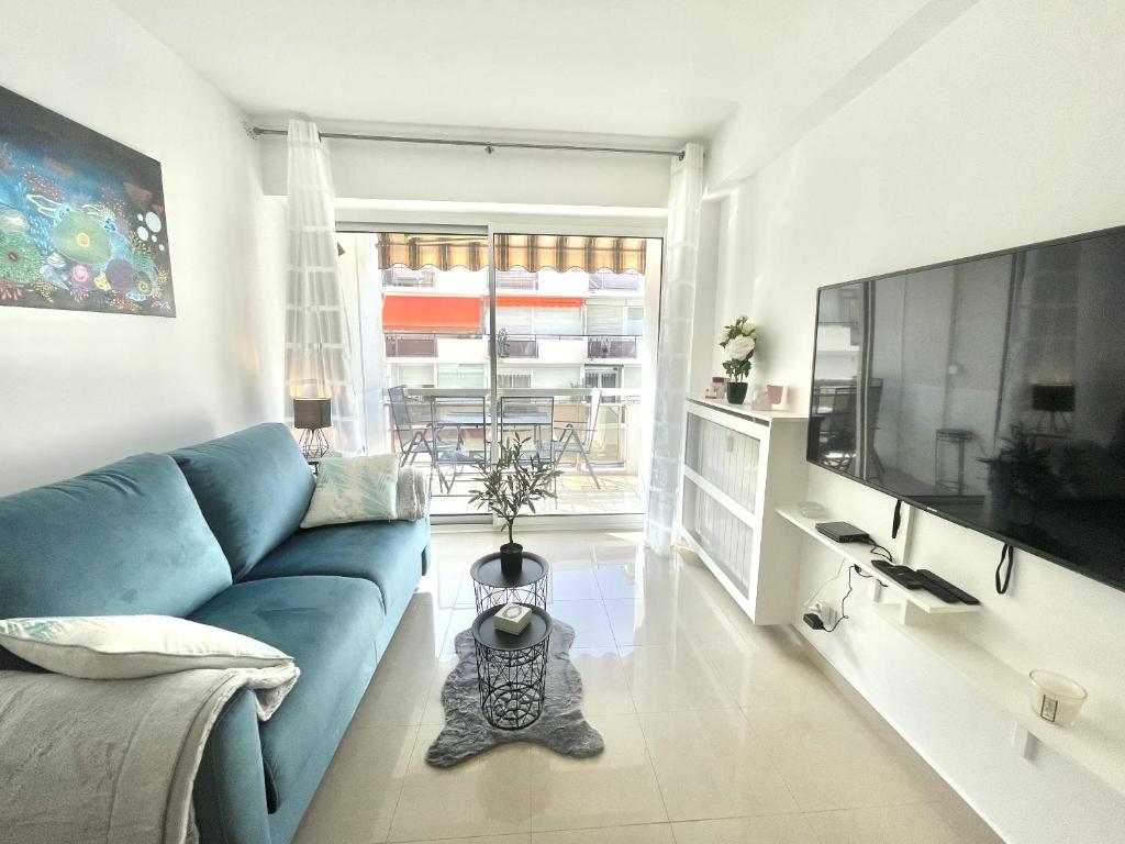 un salon avec un canapé bleu et une télévision dans l'établissement Colony 2, à Cannes