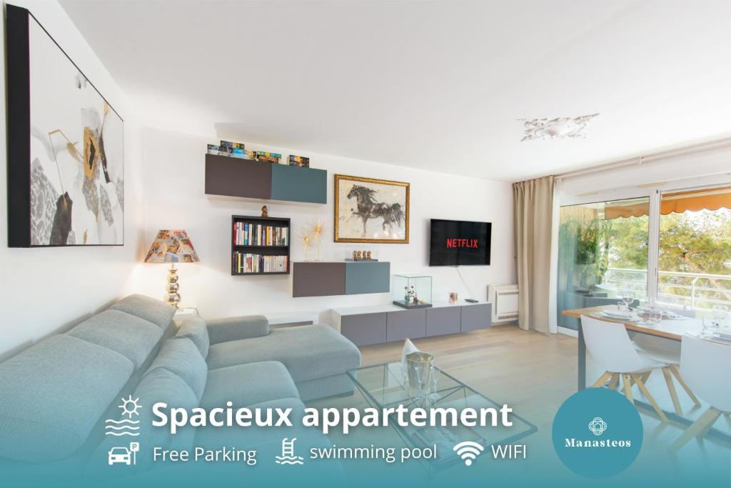een woonkamer met een blauwe bank en een tafel bij Spacieux appartement - Parking privé & Piscine in Beausoleil