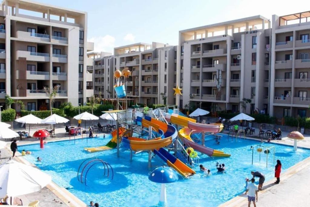 une grande piscine avec un parc aquatique doté de toboggans dans l'établissement شاليه الأصدقاء Friends chalet, à Dawwār ‘Abd Allāh