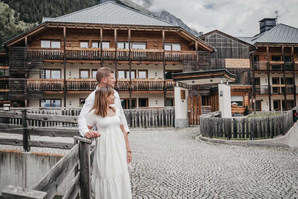 a bride and groom standing in front of a building at Exzelent Residence in Anterselva di Mezzo