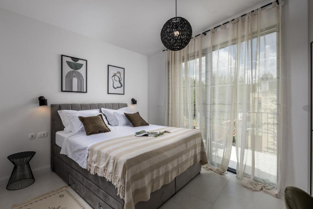 een slaapkamer met een bed en een groot raam bij Villa Medellin in Pridraga