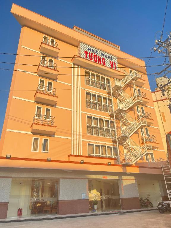 a large orange building with a fire escape at Tường Vi Motel in Hà Tiên