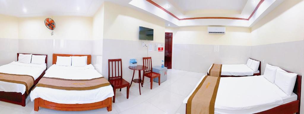 um quarto de hospital com duas camas e uma mesa em Tường Vi Motel em Hà Tiên