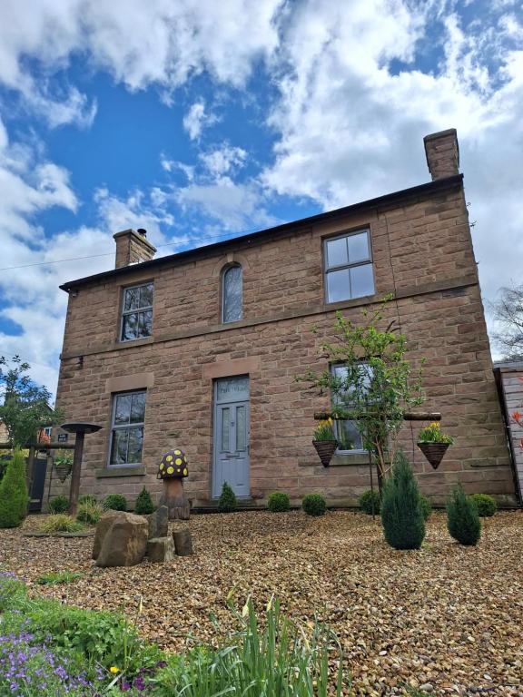 a brick house with windows and a yard at Park House Matlock in Matlock