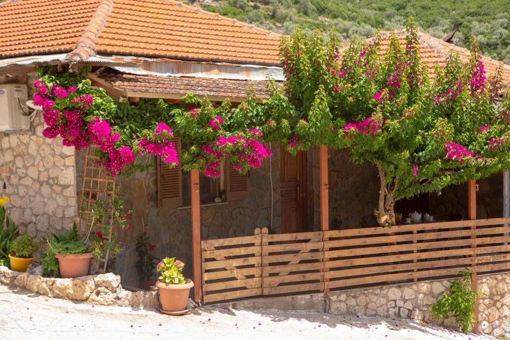 una casa con flores rosas delante de ella en Elena’s House Sivota Lefkadas, en Sivota