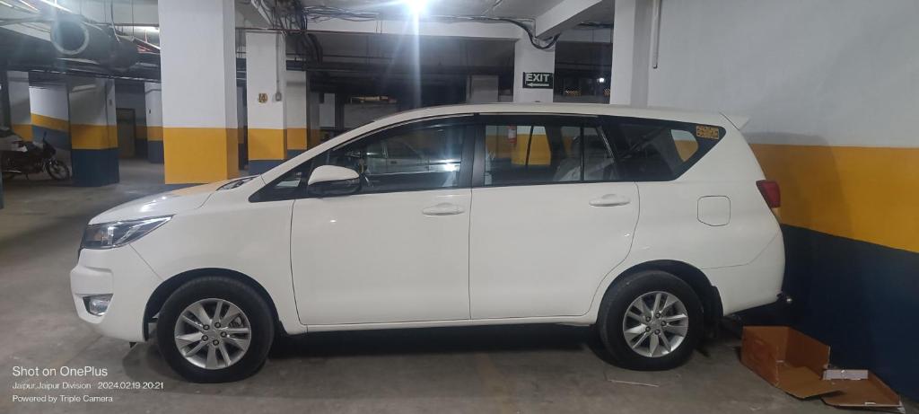 une petite voiture blanche garée dans un garage dans l'établissement Travel India cab services, à Chāndīo