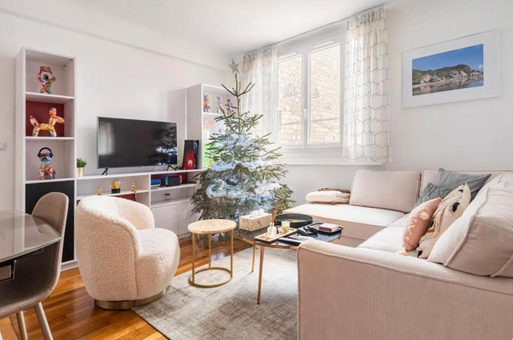 a living room with a christmas tree and a couch at Spacious Moderne & Design appartement 16em Arrondissement in Paris