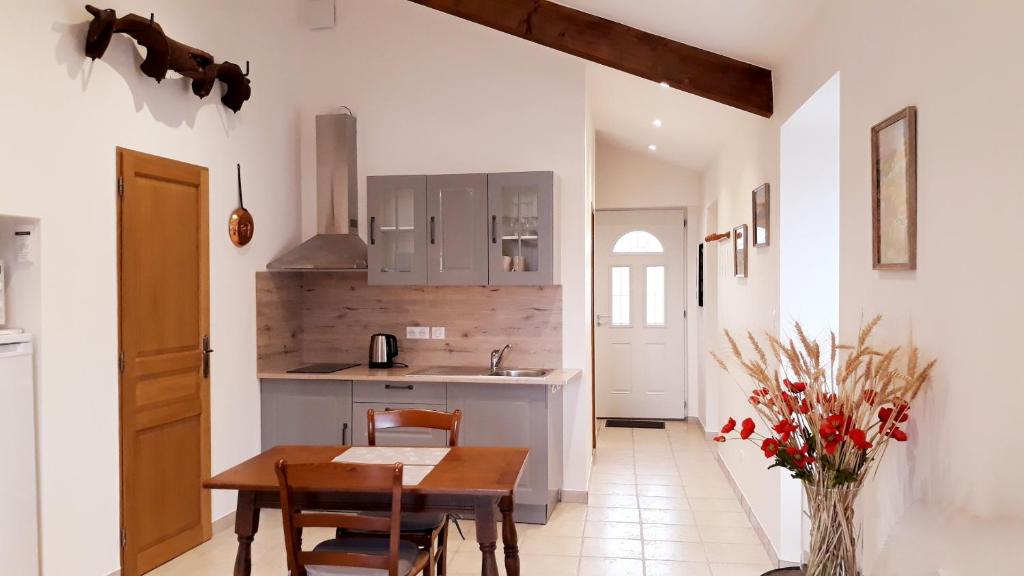 - une cuisine avec une table et des chaises en bois dans la chambre dans l'établissement La maison de Marie-Blanche, à Melve