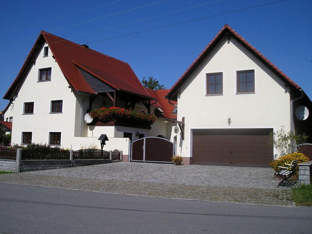 a white house with a brown roof and a garage at Sachon Modern Retreat in Dürrwicknitz