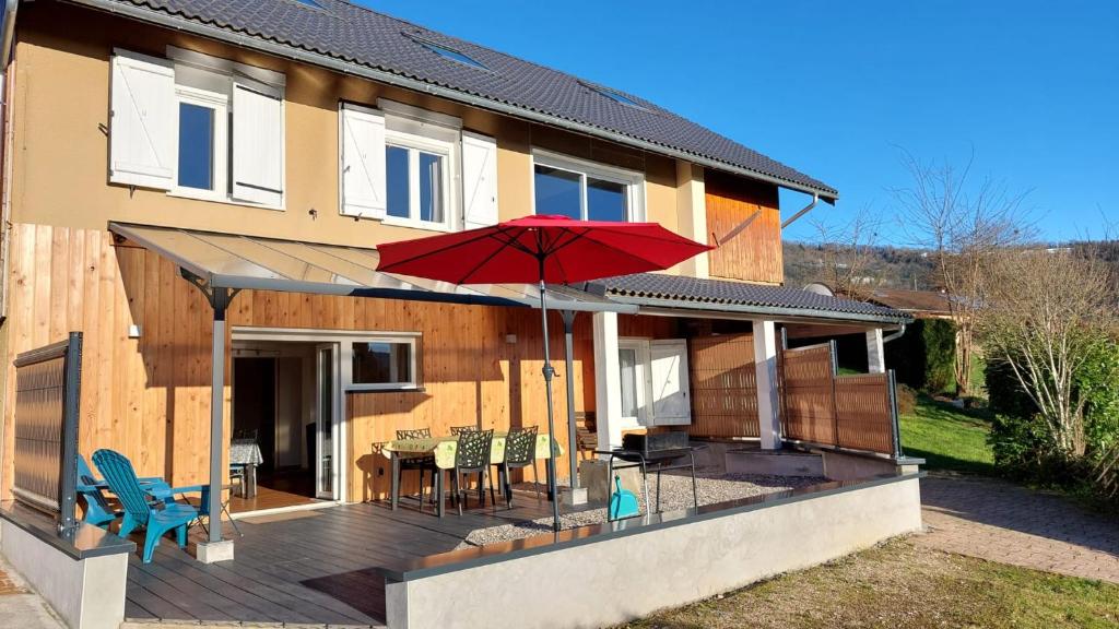 Casa con terraza con sombrilla roja en La marmotte Appartement privatif 2 chambres proche du lac d'aiguebelette en Saint-Béron