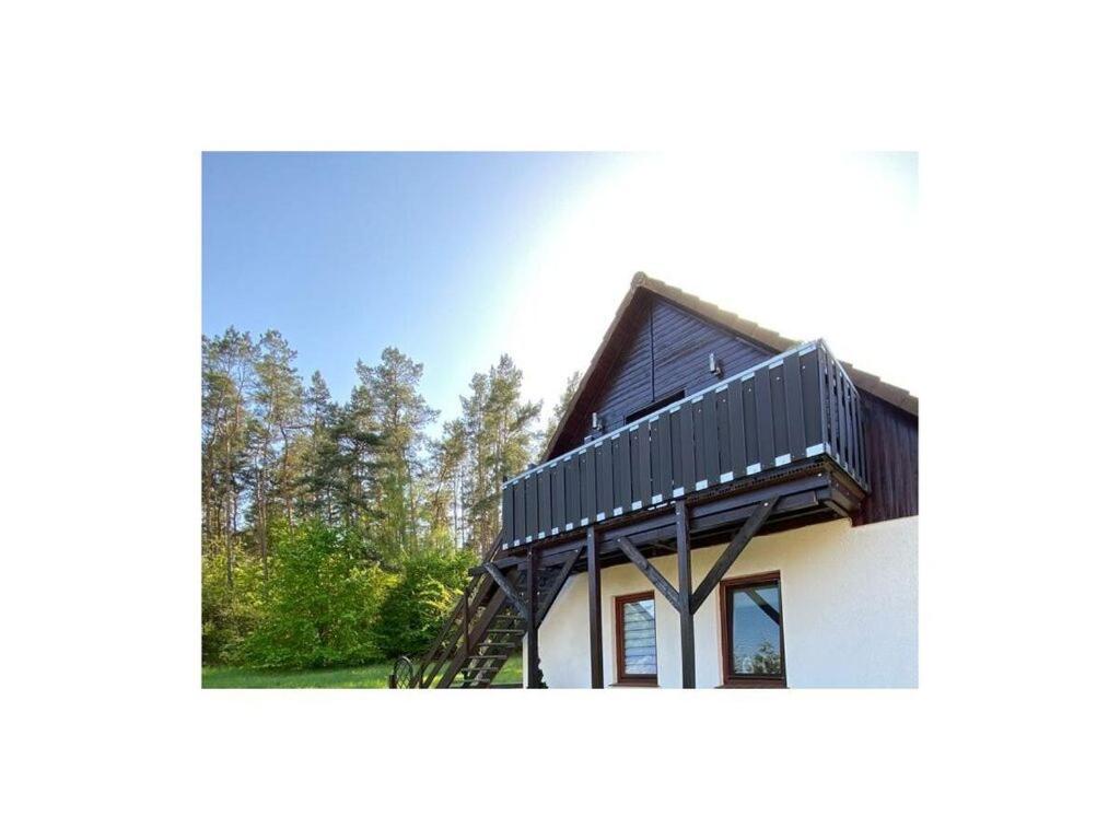 a house with a black roof on top of it at am Wald 2 Modern retreat in Kölpinsee