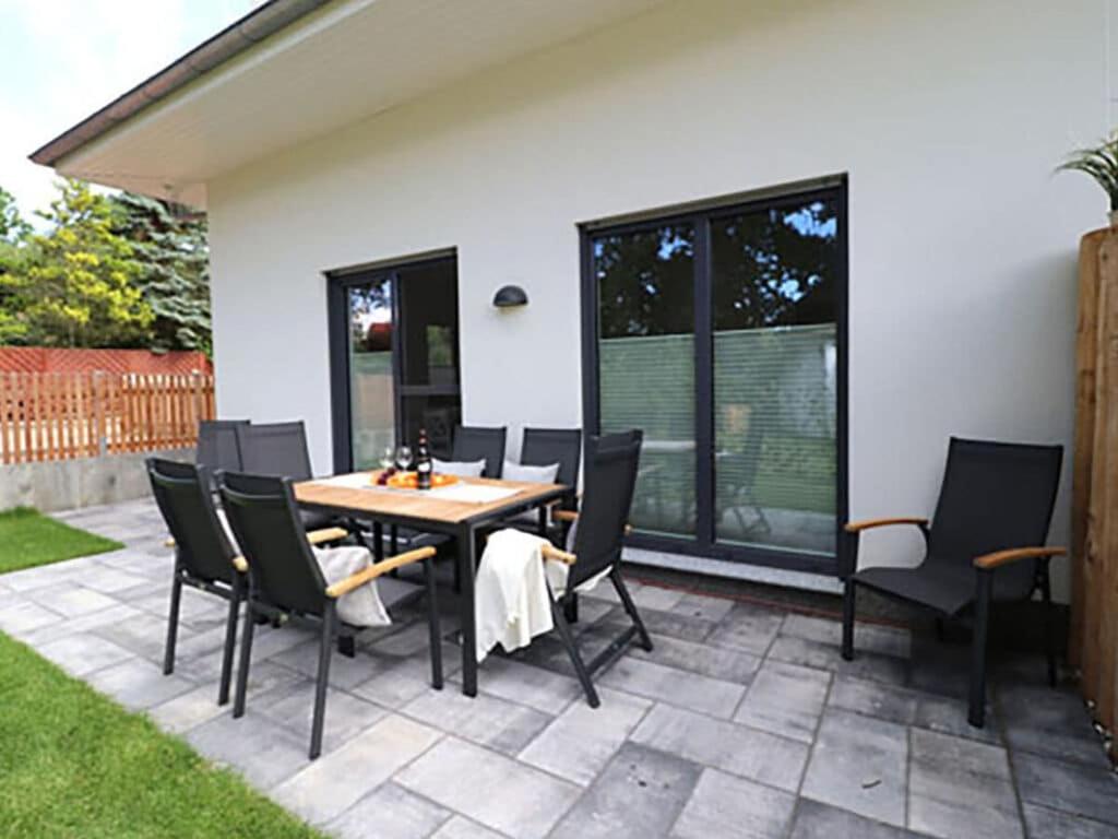 a patio with a wooden table and chairs at Villa Ostseekind in Neuhaus