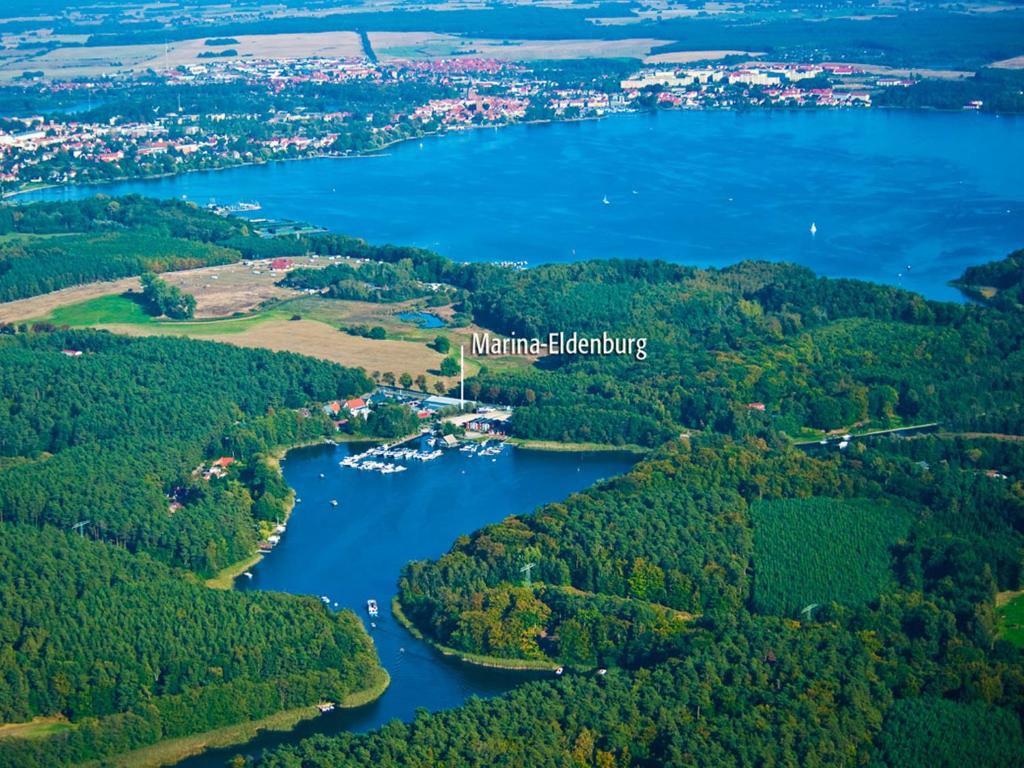 eine Luftansicht auf einen Fluss und Wälder in der Unterkunft Marina Eldenburg - Ferienhäuser und Bootsverleih am Tor zur Müritz in Waren (Müritz)