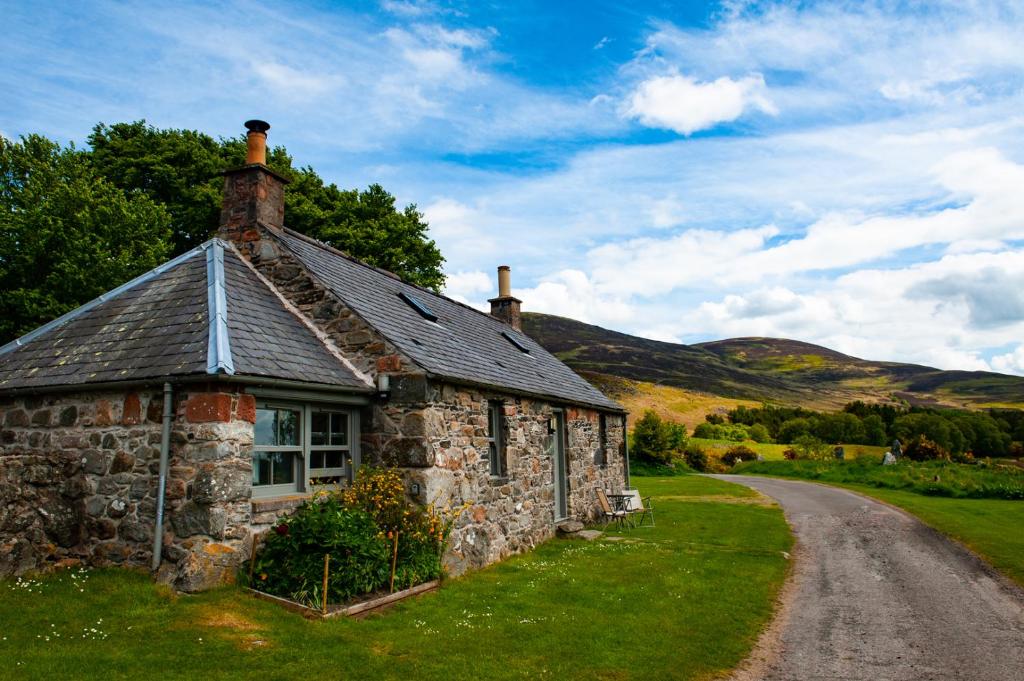 una vieja casa de piedra al lado de una carretera en Colmeallie Bothy - Seasgair Lodges en Brechin