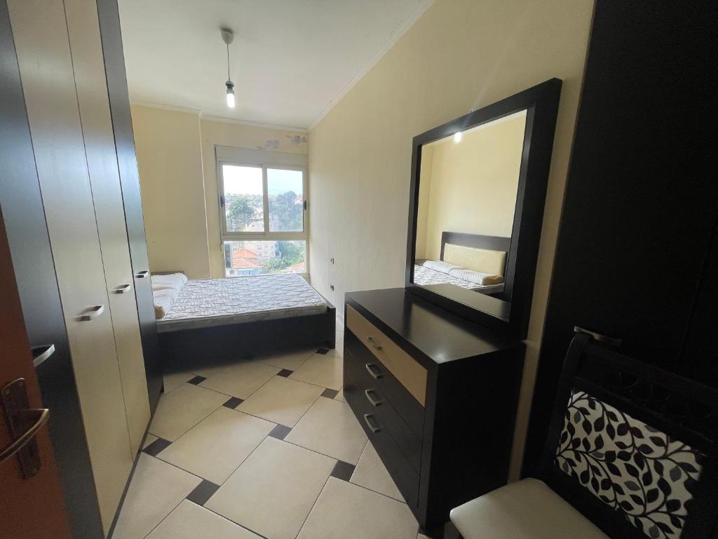 uma casa de banho com um espelho e uma cómoda com uma cama em Quality Apartaments em Durrës