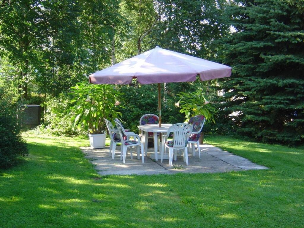 una mesa y sillas bajo una sombrilla en un patio en Bräuer Modern retreat, 