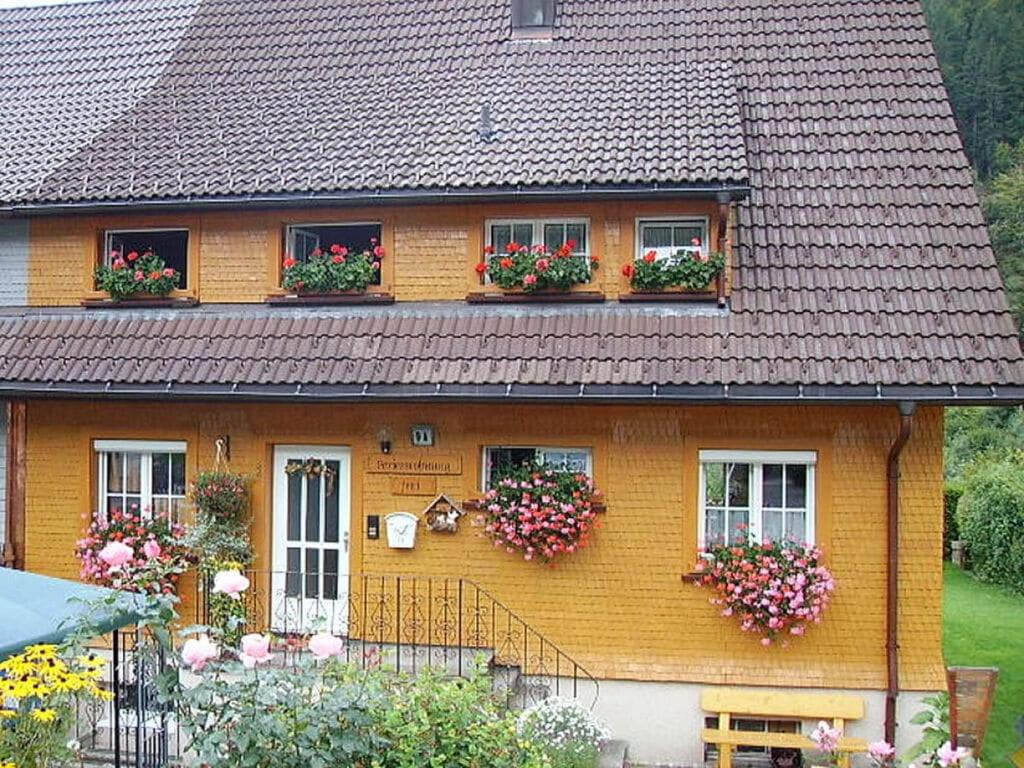 ein gelbes Haus mit Blumenkästen an den Fenstern in der Unterkunft Haus Hiller Modern retreat in Brandenberg