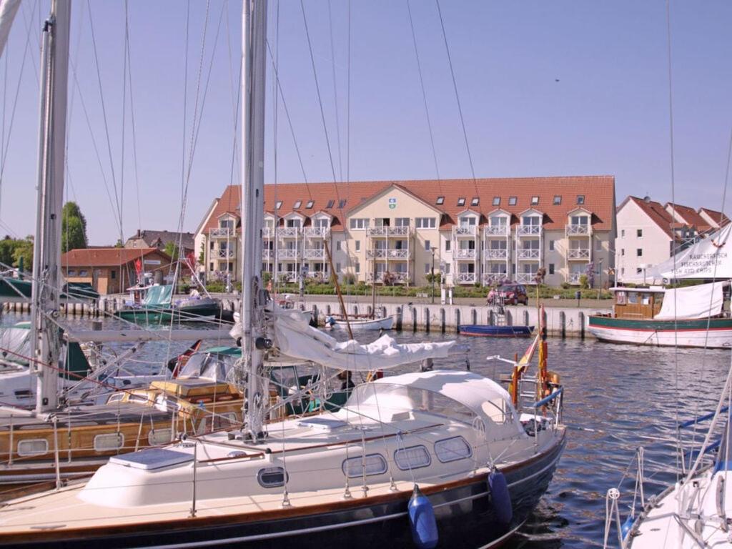 un barco atracado en un puerto deportivo con edificios al fondo en Lake View Modern Retreat, en Kirchdorf