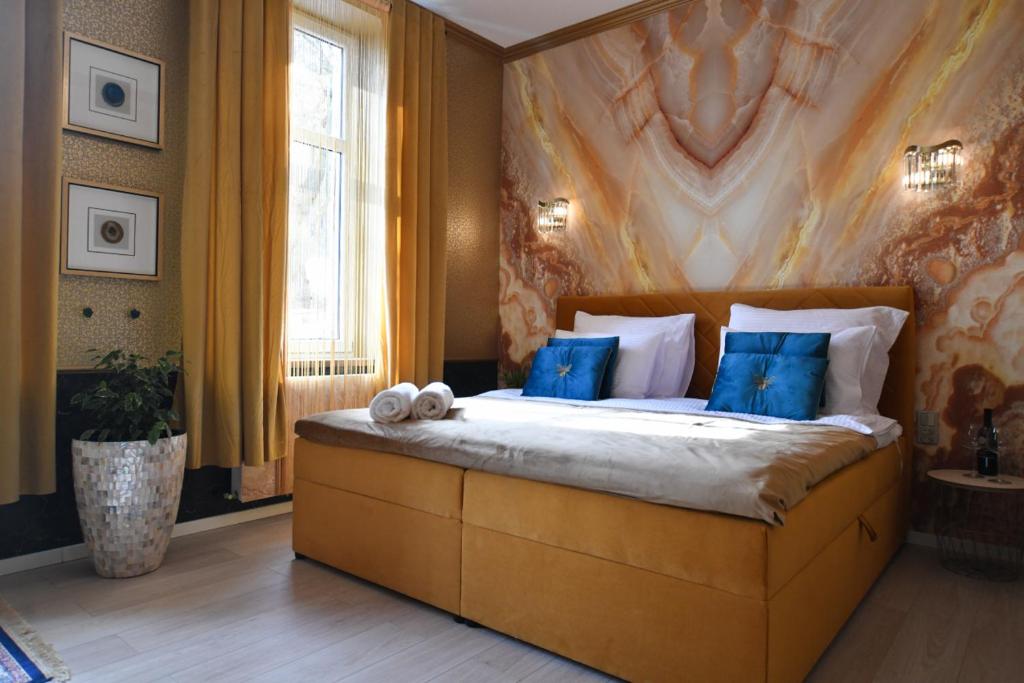 a bedroom with a large bed with blue pillows at Apartament Bursztynowa Komnata przy Zamkowej 1 w Wałbrzychu in Wałbrzych