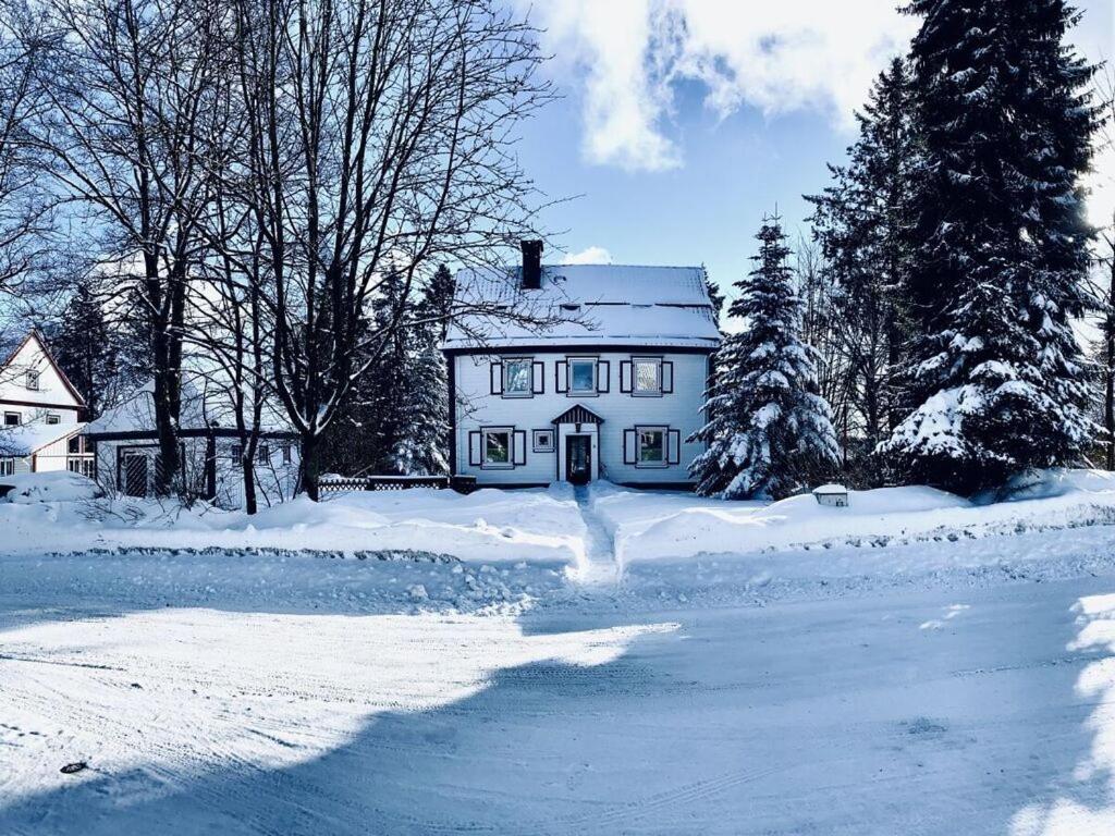 a white house with snow on the ground at The parents' house Modern retreat in Clausthal-Zellerfeld