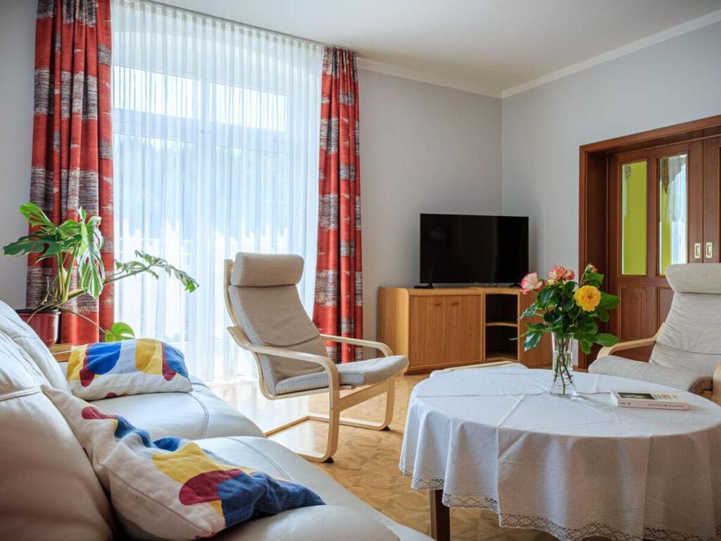 sala de estar con sofá, mesa y TV en Holiday apartments Ender en Sebnitz