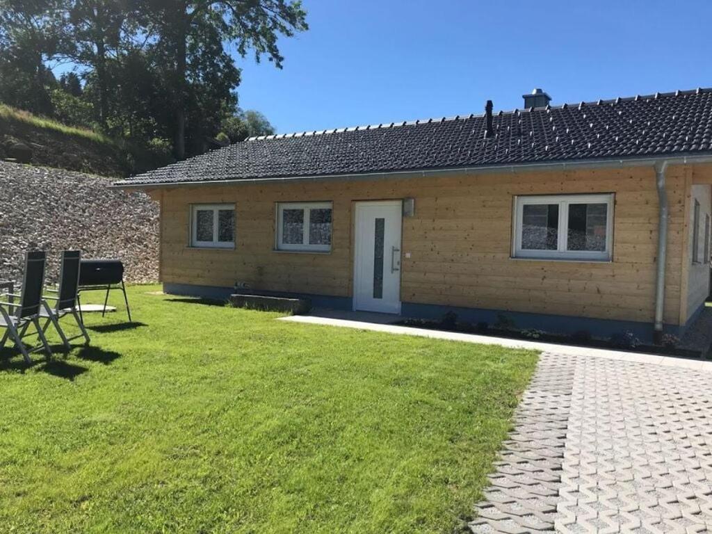 een klein huis met een grasveld ervoor bij Holiday home Baier in Philippsreut