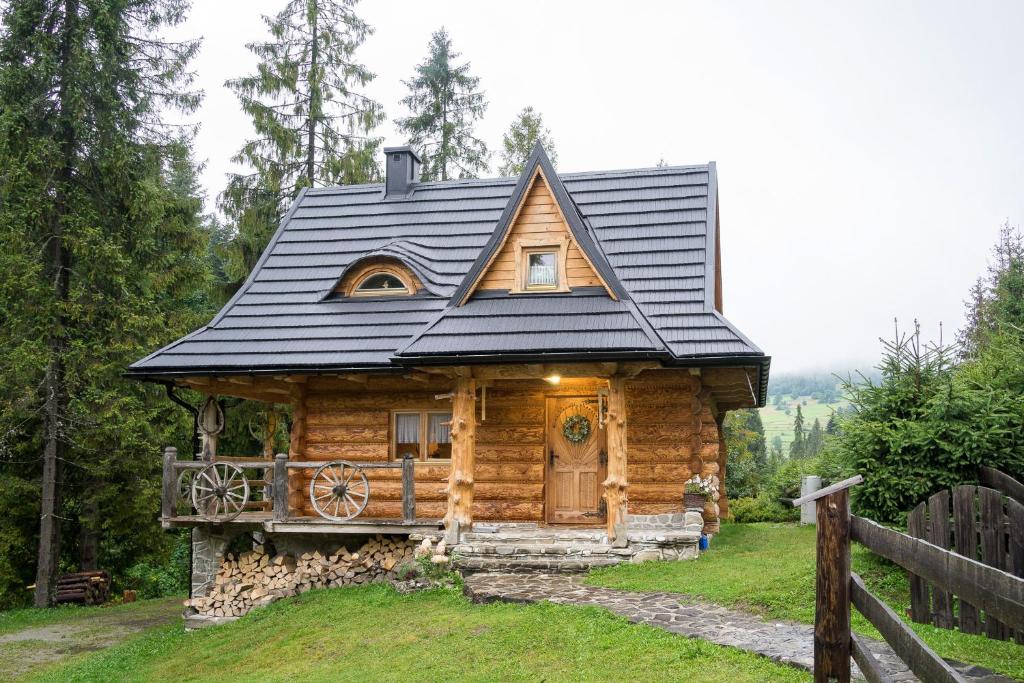 eine kleine Blockhütte mit schwarzem Dach in der Unterkunft Bacówka Polanki in Obidowa