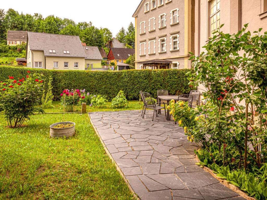 a patio with a table and chairs in a garden at Holiday apartments Ender in Sebnitz