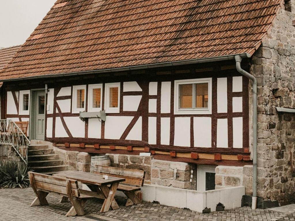 een gebouw met een houten tafel en een bank bij Ziegler Modern retreat in Ebersburg