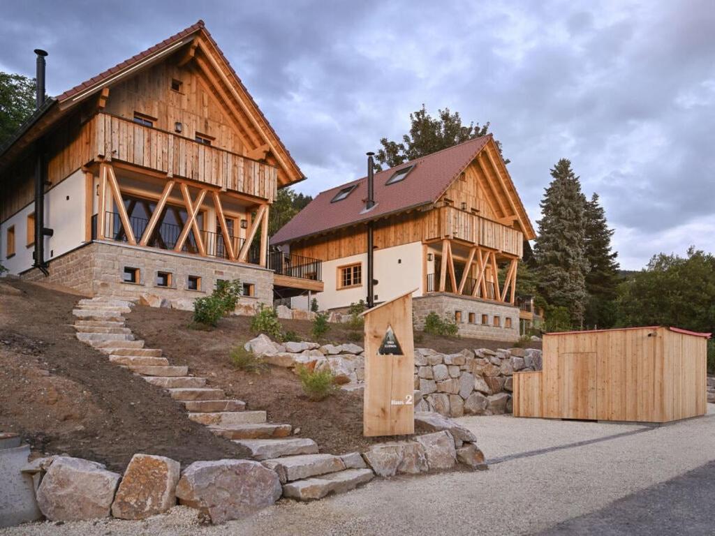 una gran casa de madera con una pared de piedra en Grandma Ludwin 1 Modern retreat, en Sasbachwalden