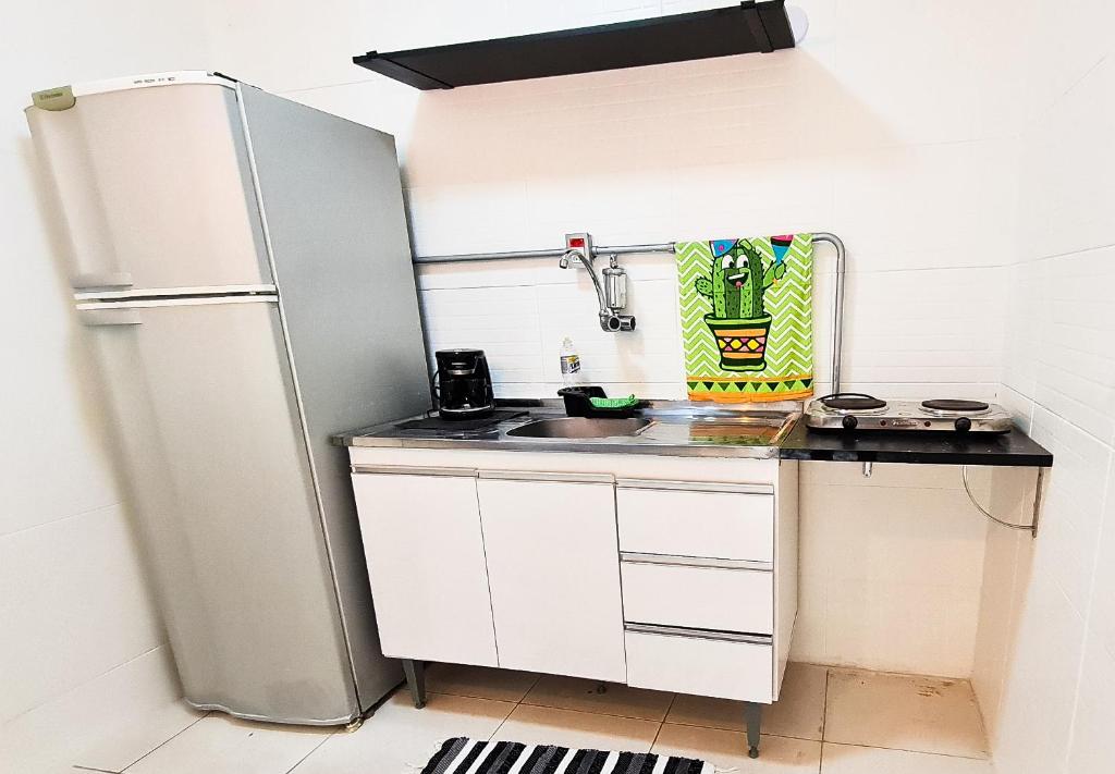 una pequeña cocina con nevera y fregadero en Residencial do Centro en Niterói