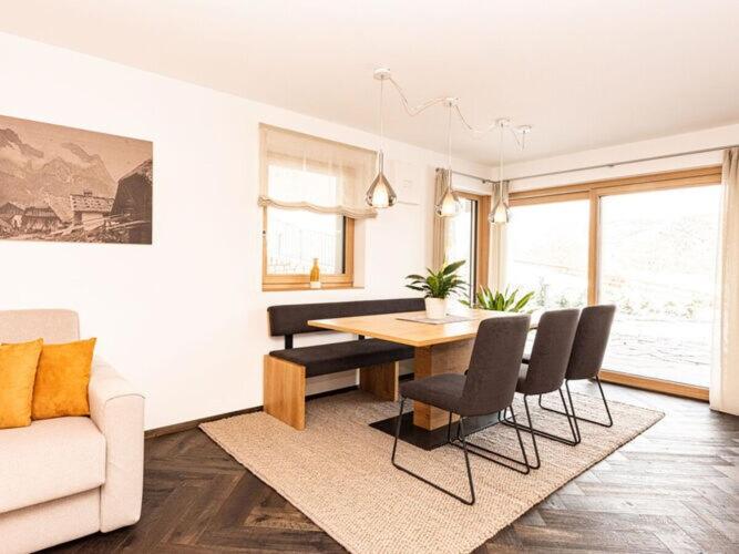 - un salon avec une table, des chaises et un canapé dans l'établissement Holiday apartment in Seis am Schlern, à Alpe di Siusi