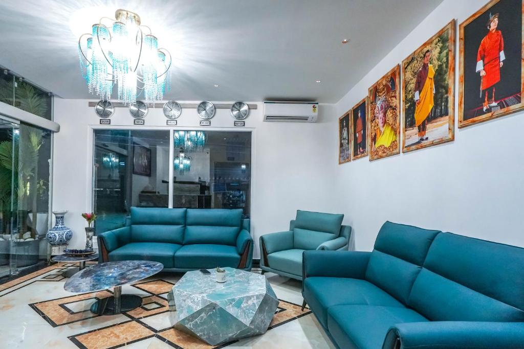 a living room with blue couches and a table at Dey Ngyam Boutique in Geylegphug