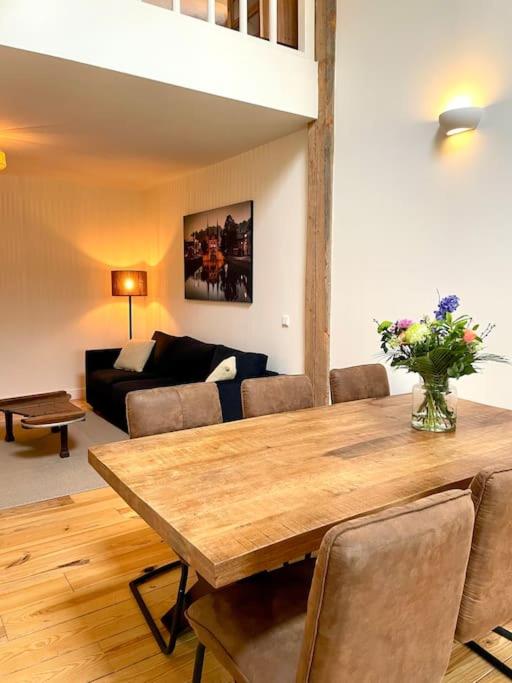 a living room with a wooden table and a couch at Appartement Sneek in Sneek